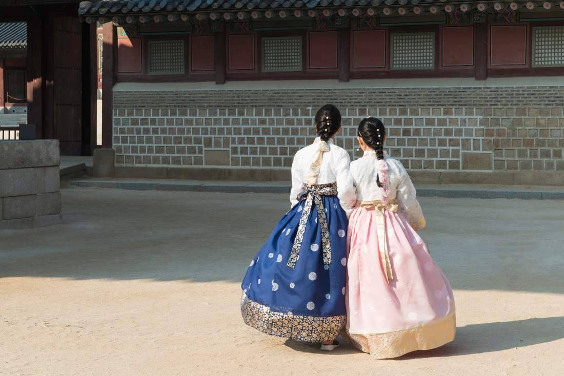 Asian Korean woman dressed Hanbok in traditional dress walking in Gyeongbokgung Palace in Seoul, South Korea.